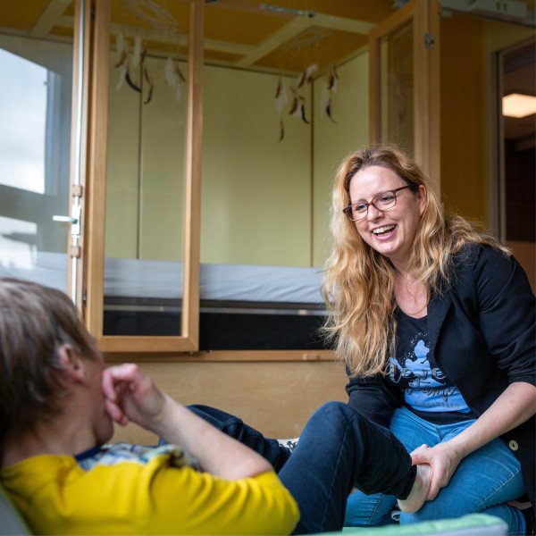 Begeleider lacht naar client